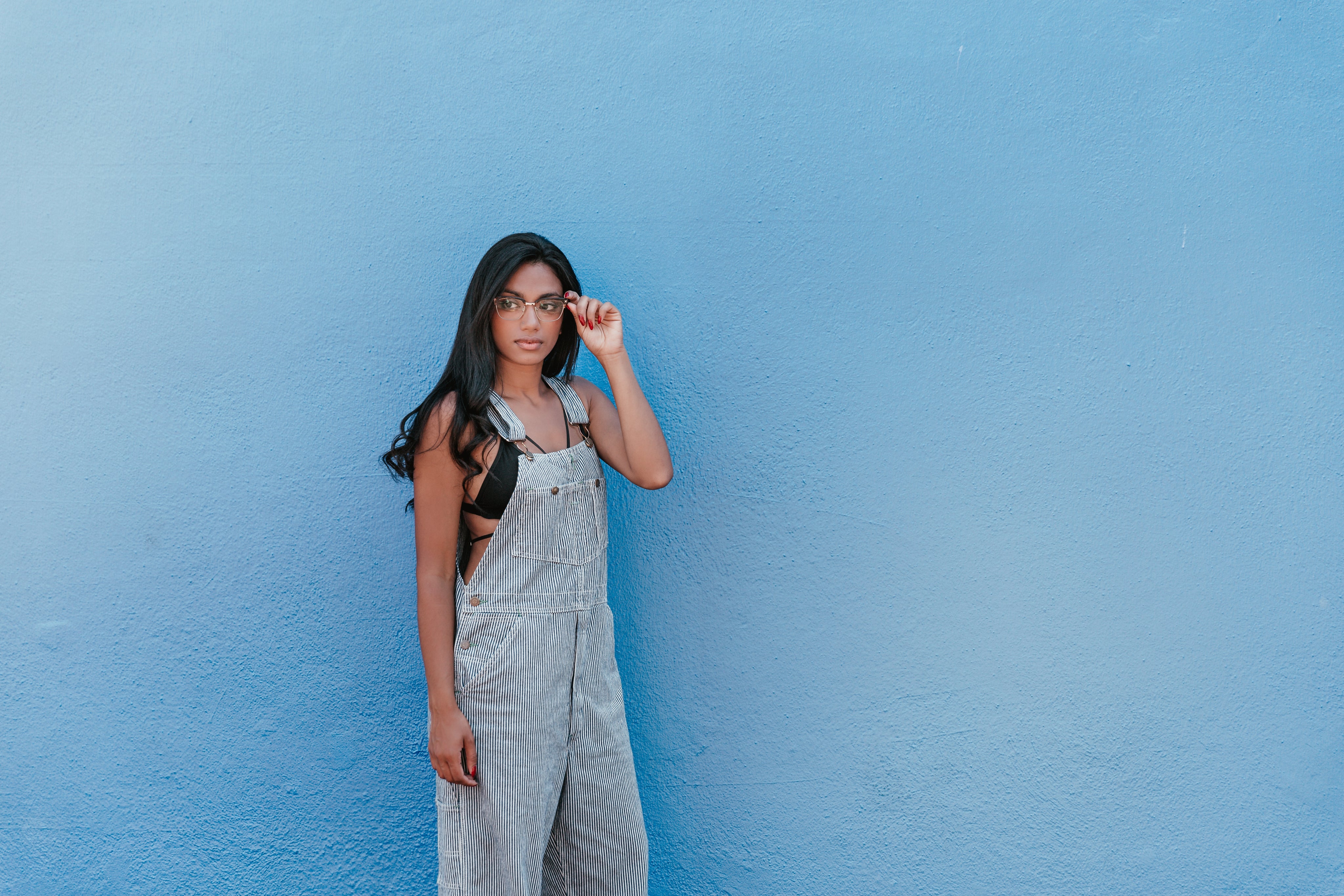 files/woman-with-blue-wall-adjusts-glasses.jpg